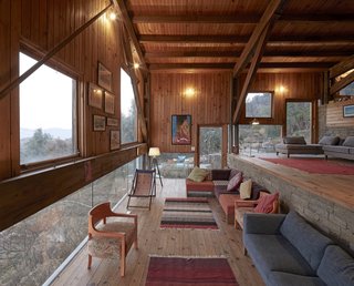 The living room overlooks the landscape through a low horizontal band of glass.