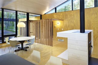 A screen of wooden posts marks the entrance and continues from the exterior to the interior.