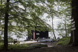 Blackened timber clads the boathouse.