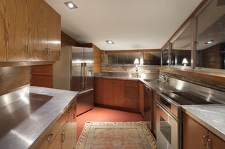 Stainless steel countertops, provided from the homeowner's business, Flour City Ornamental Iron Company, has replaced the linoleum countertops specified by Wright.