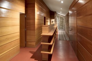 The glazed entrance is accessed through the carport and opens up to a long north-south gallery bisected by a low bookcase.