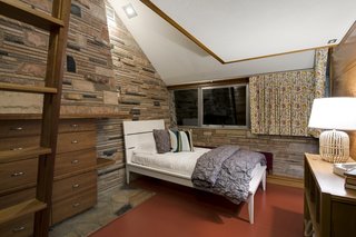 Set on a concrete slab, the home features bearing walls and a chimney built of scrap marble blocks that have been laid in a horizontal pattern.