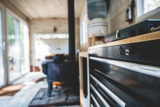 A Husky tool bench with a butcher-block top was repurposed into the kitchen counter with storage in the form of spacious sliding trays.