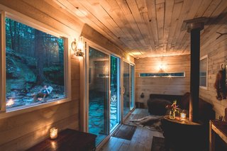 The glazed doors and windows were placed on opposite sides of the cabin to maximize light and transparency, as well as to optimize views of the outdoors.