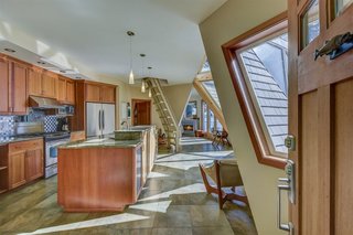 The kitchen has timber cabinetry, granite countertops, and ceramic tile flooring.