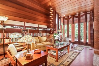 Skinny horizontal windows make up the great room’s glazed wall, providing views of the outdoor patio and gardens beyond.