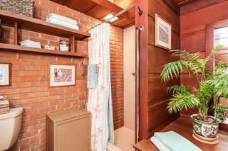 The master bathroom boasts an exposed brick wall.