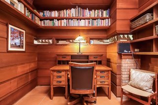 Built-in shelving wraps around the workspace, located next to the second bedroom.