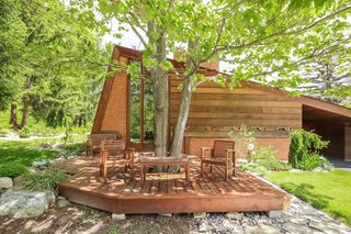 An outdoor deck that wraps around a tree is accessible from the master bedroom.