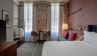 Exposed brick walls can be seen in the Premium King Suite, which overlooks views of Magazine Street.