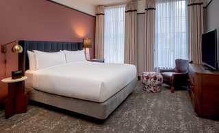 The Publisher's Suite also enjoys views of Magazine Street below. All rooms are furnished with ink-colored leather headboards, accent furnishings from Bryan Ashley, floral patterns, and brass and walnut accents throughout.