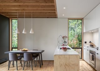 Timber ties the kitchen and dining area to the outdoors, from the exposed wood ceiling joists to Arauco plywood on the island topped with Corian solid surface.