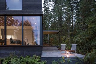 A small outdoor patio with precast concrete pavers is placed on the west side of the home to soak up the afternoon sun. The patio connects to a series of trails that lead through the forest and to the beach. 