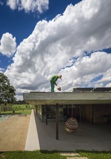 A staff worker tends to the grass roof.