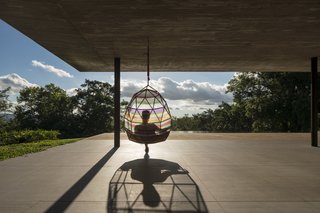 In another contrast to the horizontality of the house, the architects added a translucent, multi-colored cocoon chair by Patricia Urquiola that hangs from the ceiling.