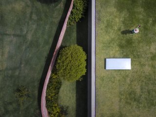 "Paradoxically, it defines the different relationships between the internal and external spaces," explains the firm. "The wall—which is usually a symbol of division and isolation—is, in this project, at times concave and at others convex, embracing the entrance garden and creating transparencies as well as offering protection from the street."