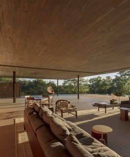 The living room is furnished with low-lying timber furniture from studios like Ronan & Erwan Bourollec and Liceu de Artes e Ofícios.