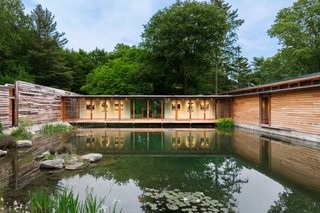 The cross-axis bridge is faced with full-height glazing to overlook views of the pond.