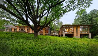 The architects have mitigated the sloped terrain by elevating parts of the single-story residence on rectangular pillars.