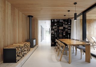 A wood-burning stove anchors one side of the dining area that connects to the sheltered outdoor terrace.