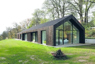 The master bedroom overlooks the landscape through a glazed gable wall, which is shaded with a deep overhang.