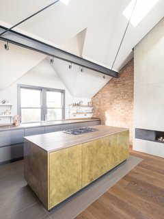 Stainless steel shelving and appliances tie the kitchen into the home's chic, minimalist style.