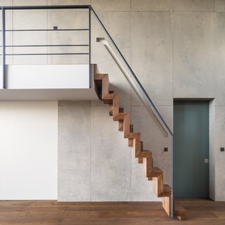 Sculptural timber-paddle stairs lead up to the mezzanine bedroom.