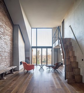 The interior boasts an industrial aesthetic achieved by the exposed brick wall, concrete surfaces, and copper finishes.