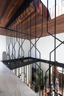 Instead of a simple railing, Gracia has installed a sculptural metal screen that lets views and light seamlessly pass through.