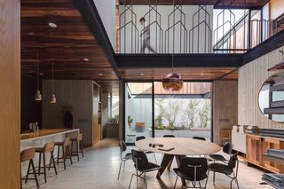 Eames molded plywood chairs are arranged around a round midcentury-modern dining table.