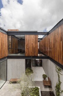 Concrete walls dominate the ground floor, while the first floor is clad in Ipe. "The upper-level white walls and Ipe wood ceiling gives the same contrast, but in a more peaceful way for the sleeping quarters," Gracia notes. 