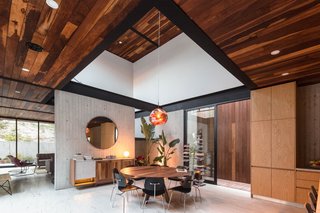 Tom Dixon's mesmerizing Melt Pendant Lamp hangs from a raised ceiling over the dining table. The dining room credenza is Jorge's original design.