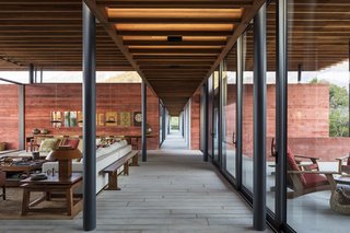 An east-facing view of the central circulation hallway is flanked with full-height, dark-gray anodized aluminum windows.