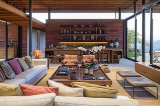 The outdoor landscape is brought indoors through the continuation of the red concrete walls and ample glazing.