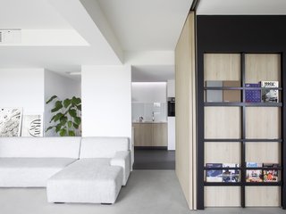 A view looking toward the kitchen with the walk-in wardrobe - concealed door incorporating magazine display camouflaging its entryway - serving guest room to the right.