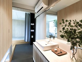 To free up space for a bathtub and separate shower stall in the master bathroom, the vanity and sink have been moved next to the full-height wardrobe that doubles as a divider.