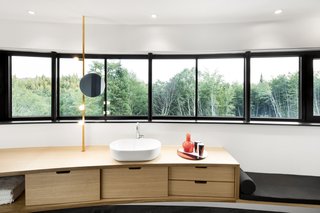 The spacious master bedroom boasts views of the forest through ribbon windows.