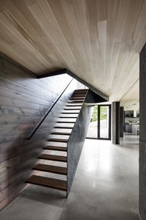 A floating staircase leads up to the bedrooms on the upper level.