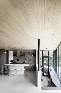 The kitchen and dining areas serve as the heart of the home and connect to a small greenhouse via stairs.