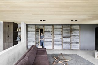The timber doors of a former garage have been repurposed into a room partition that separates the main living area from the rest of the ground floor.