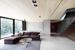 The concrete bearing walls are left exposed in the interior to tie the living spaces with the rock outcroppings.