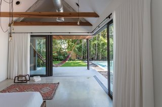 Sliding glass doors dramatically open the master bedroom up to the outdoors.