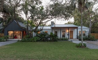 The dark and gabled addition offers sharp contrast against the low-lying white-painted bungalow. Elements such as the steel pillars were repeated in both structures for continuity.