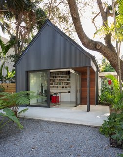 The gabled addition is topped with a standing seam metal roof and is clad in vertical corrugated metal siding.