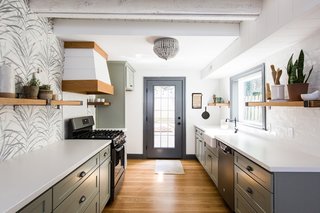 The white countertops are made from concrete and the wooden cabinets have been painted a subtle shade of sage. The floors are white oak hardwood.