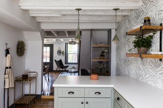 Twin pendant lights hang above the breakfast bar at the far end of the kitchen.