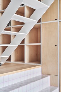 The thin white staircase contains open risers to let natural light pass through.
