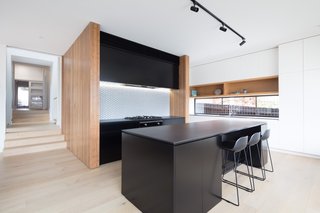 Blackbutt timber has been applied to the walls bookending the kitchen unit.