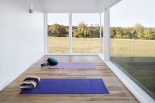The meditation room overlooks a nearby hilltop in one of the clients' favorite views, framed by floor-to-ceiling glass windows.