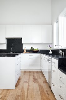 The kitchen is fitted with soapstone countertops and backsplashes from Architectural Tile & Stone, and white-painted custom cabinets from B Squared Woodworks.